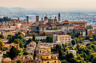 Panoramic view of Bergamo Alta featuring towers and a medieval basilica